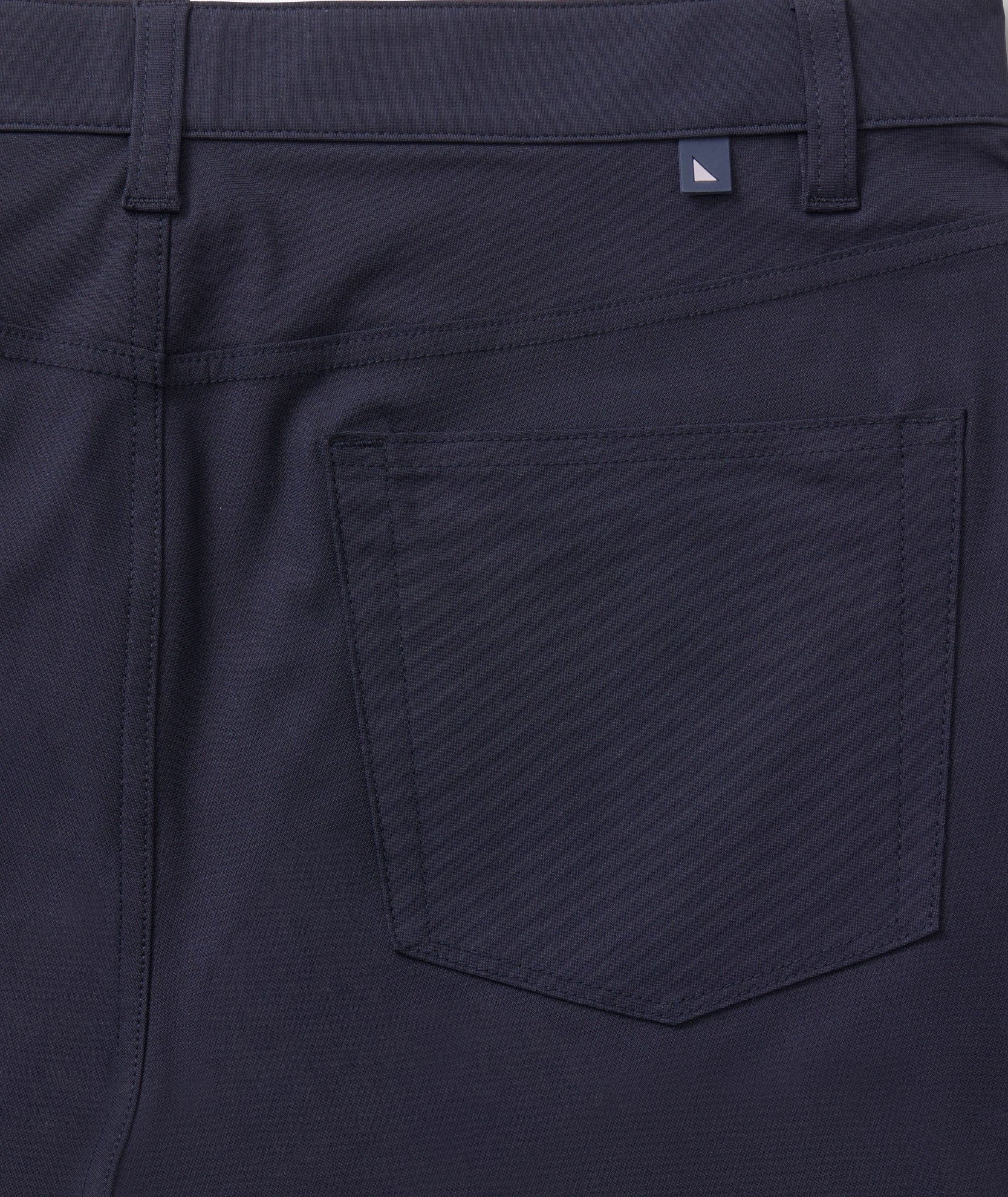 Model is wearing UNTUCKit 5-Pocket Tech Pant in Black.