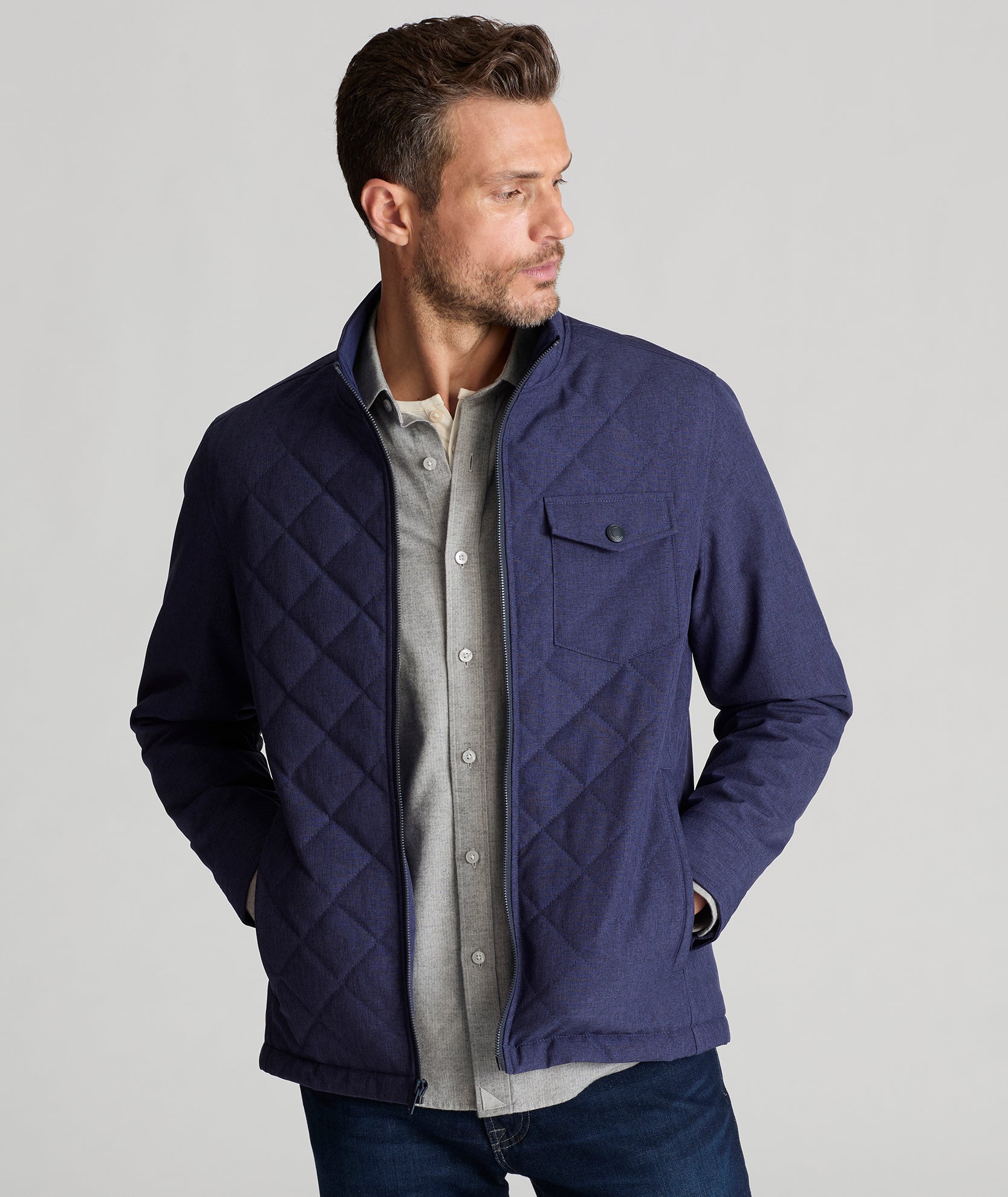 Model is wearing UNTUCKit Gardner quilted jacket in patriot blue.