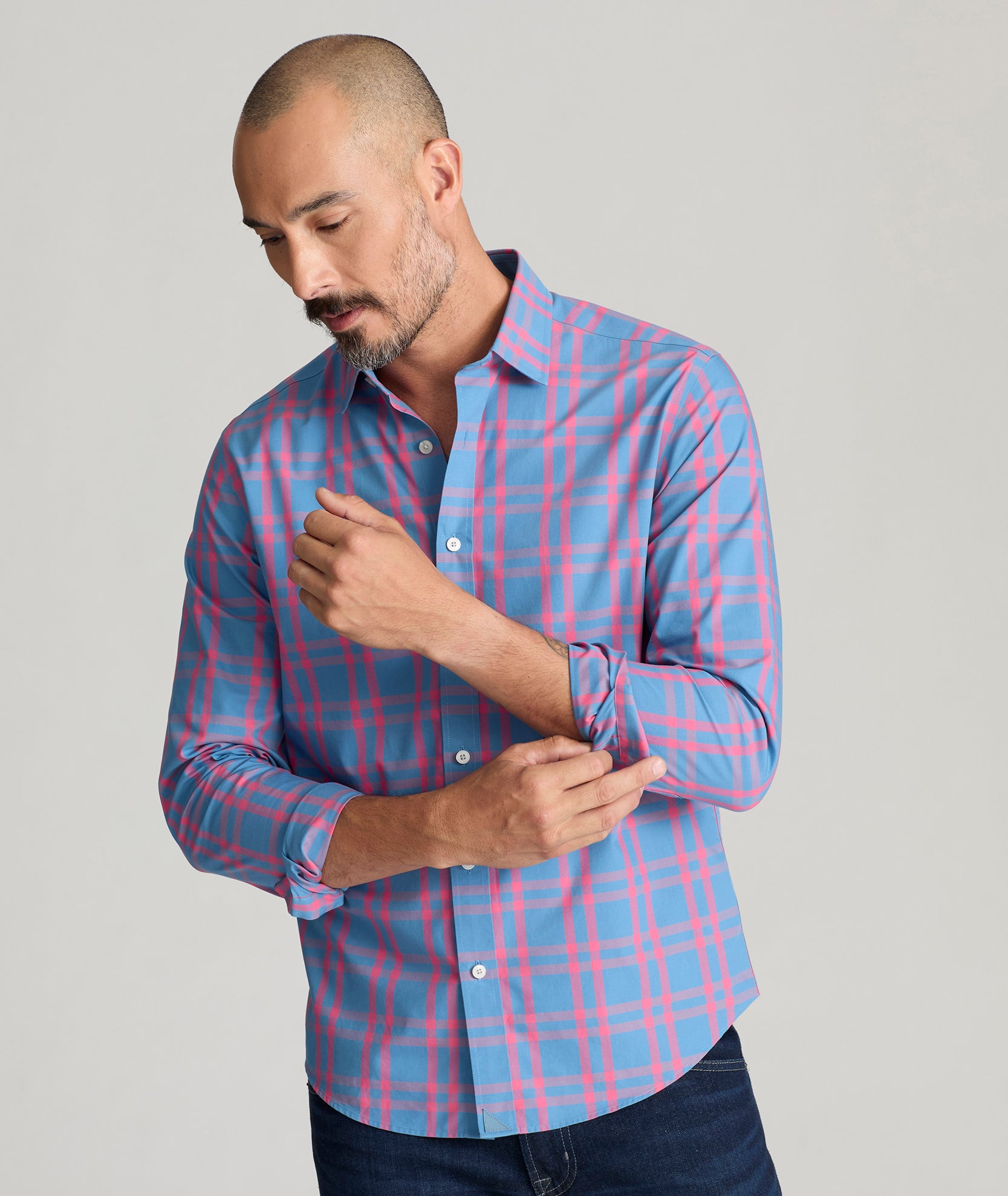 Model is wearing UNTUCKit Howard shirt in navy with pink checks. 