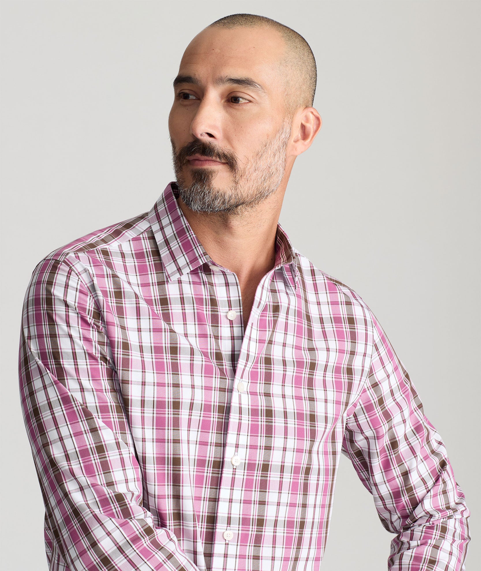 Model is wearing UNTUCKit parrish wrinkle free white grounded maroon plaid shirt. 