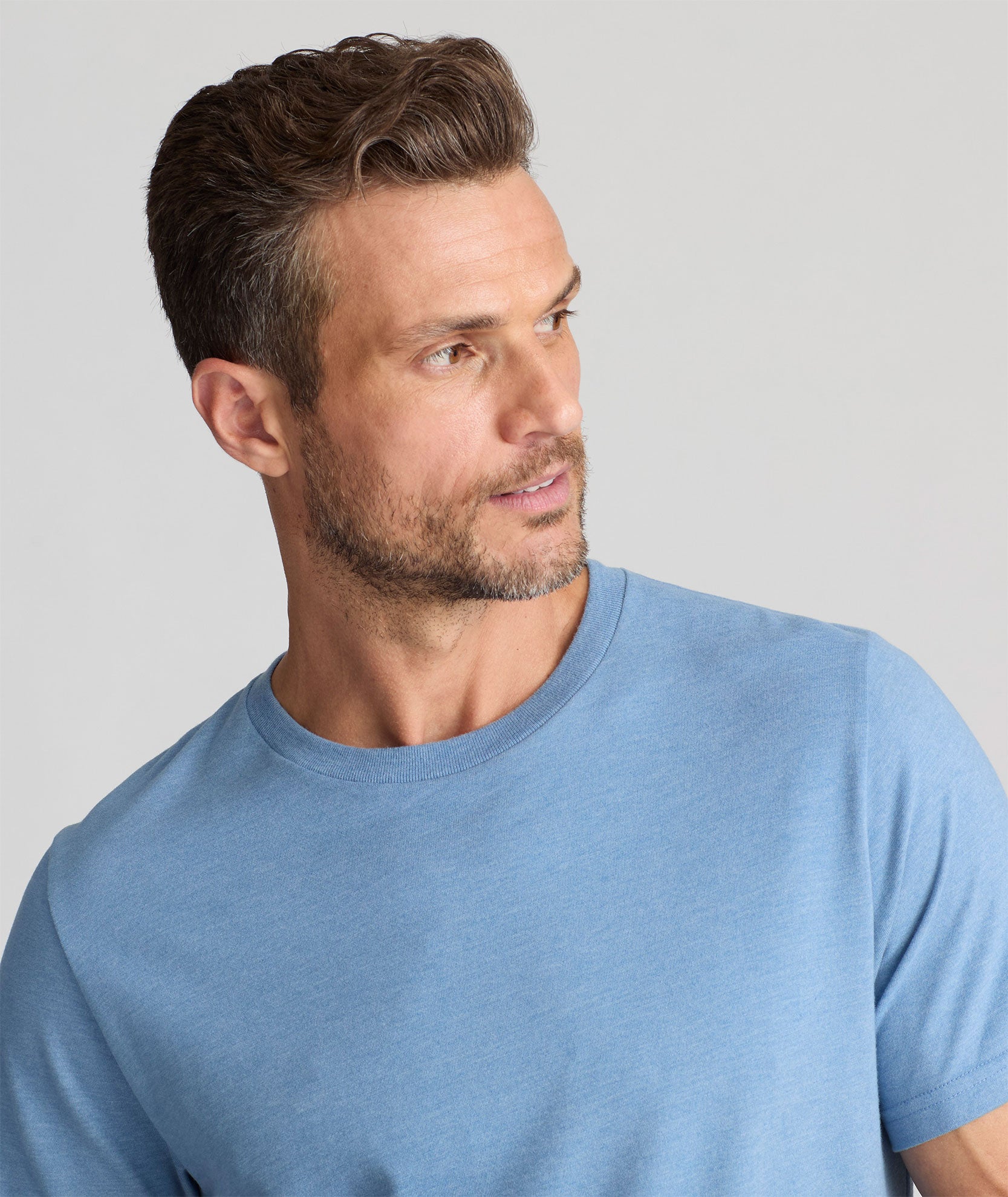 Model is wearing UNTUCKit saxum Ultra Soft tee in soft blue. 