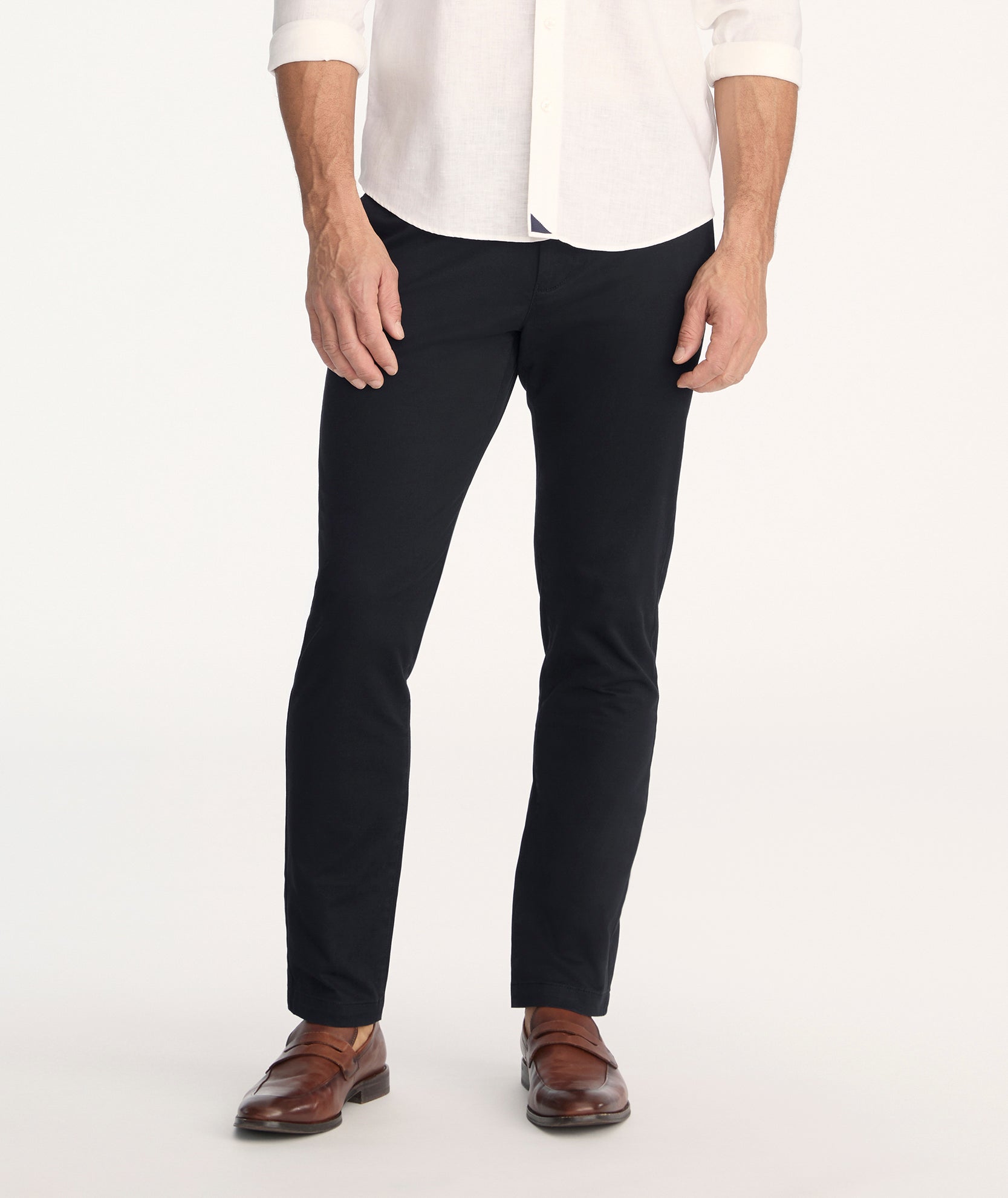 Model is wearing UNTUCKit Classic Chino Pants in black. 